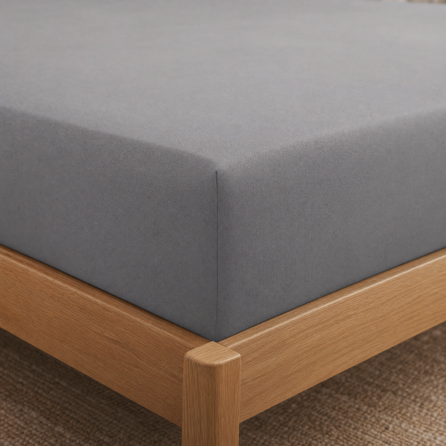 Fitted sheet corner pulled tight and snapped snugly over the mattress