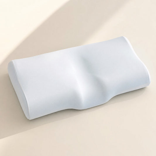 Thin contoured memory foam pillow photographed from the side on a plain surface