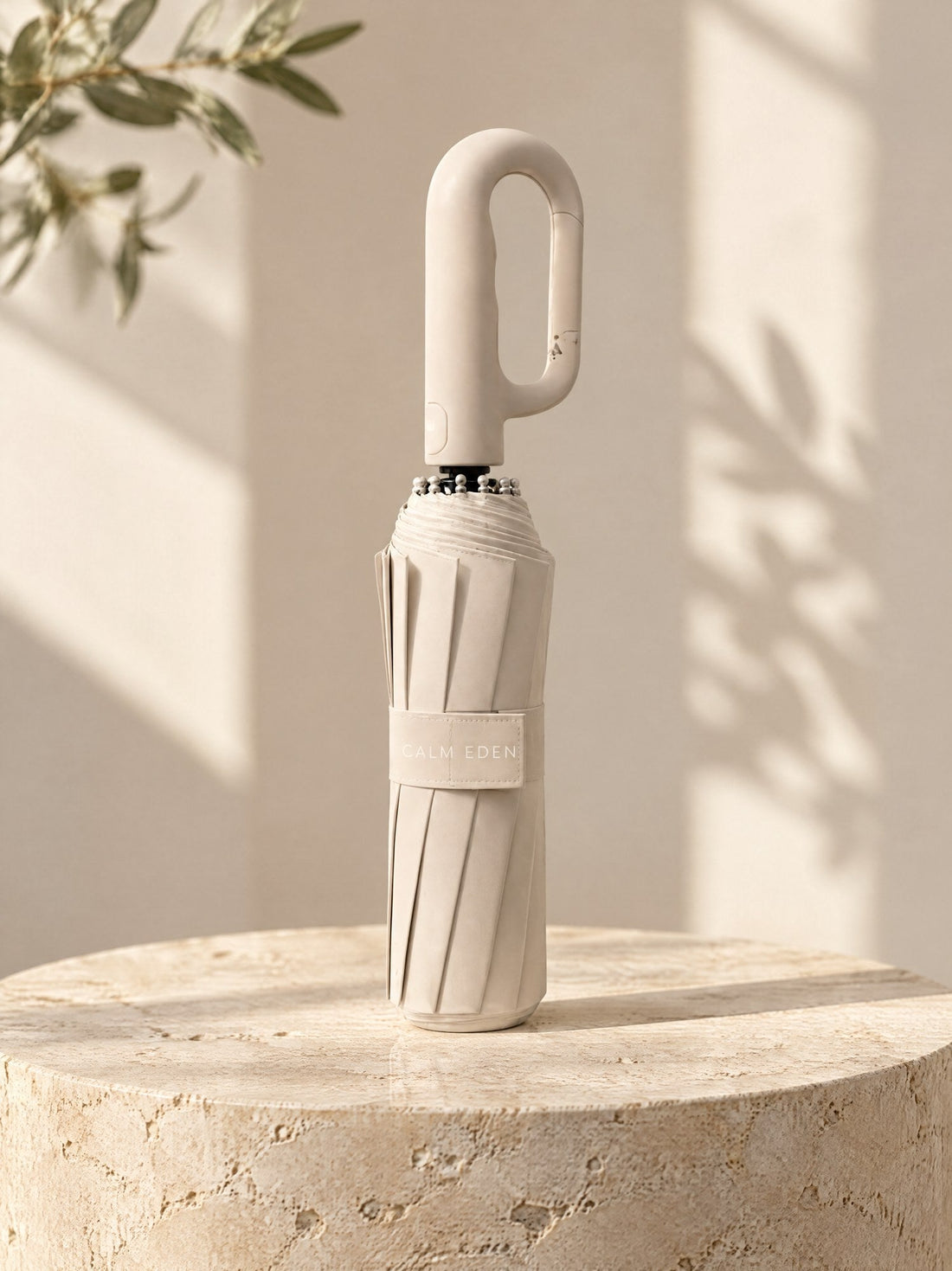Beige Haven umbrella, folded, on a stone plinth