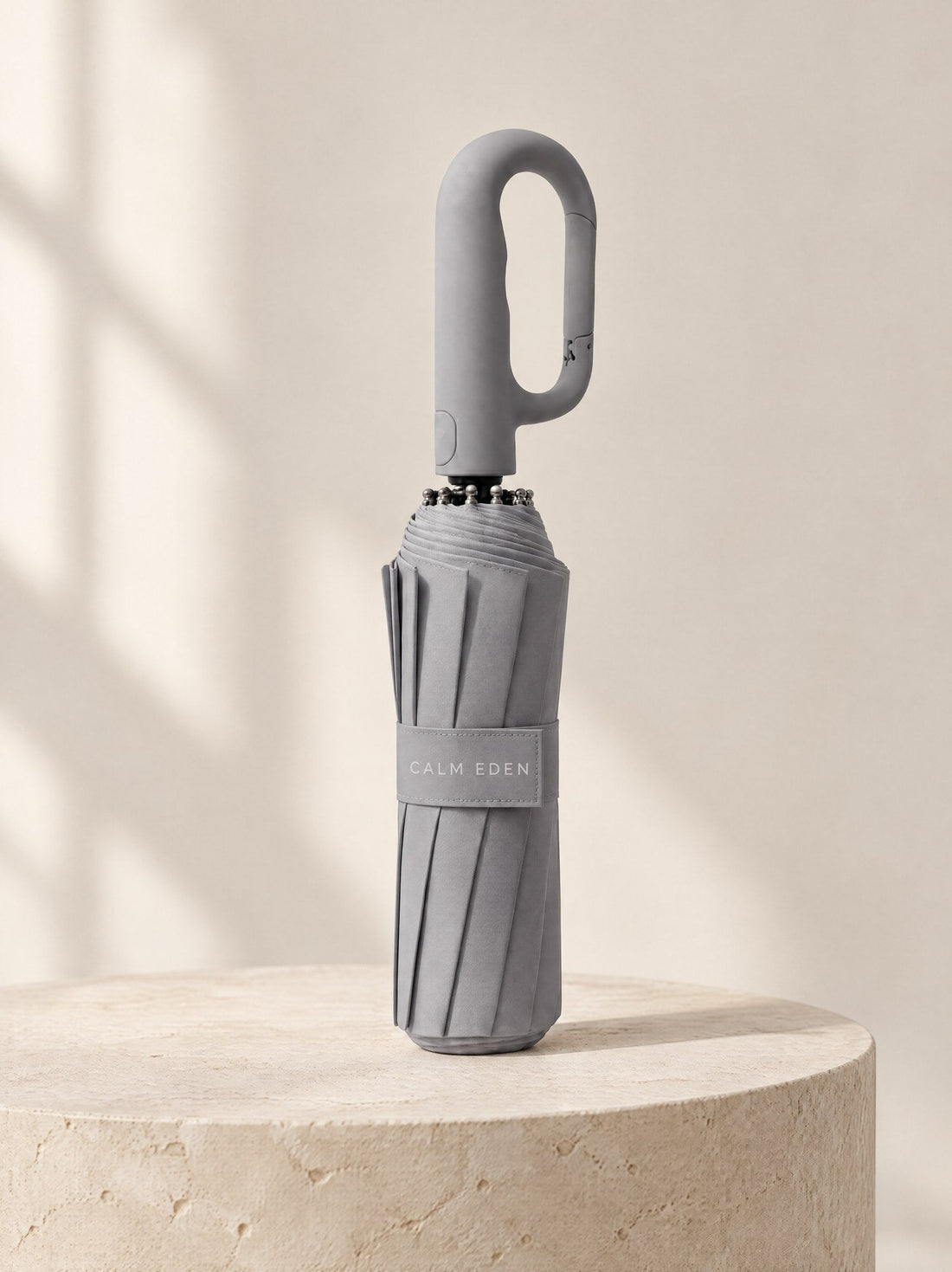 Gray Haven umbrella, folded, on a stone plinth