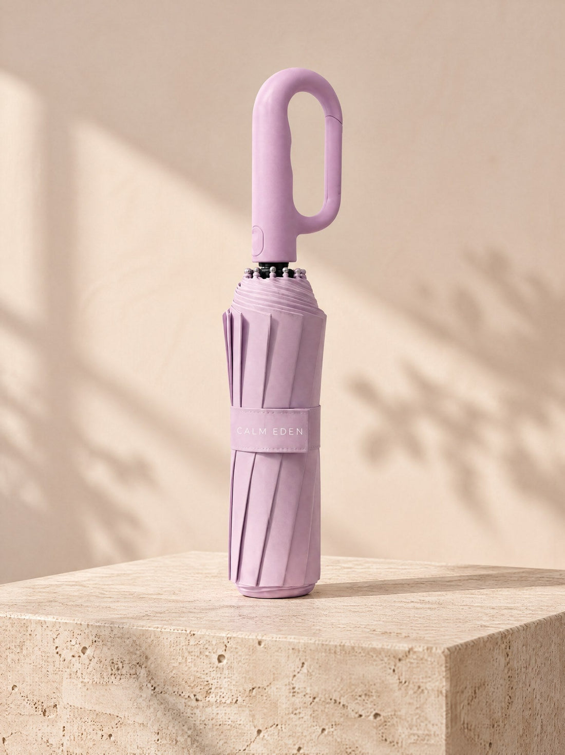 Pink Haven umbrella, folded, on a stone plinth
