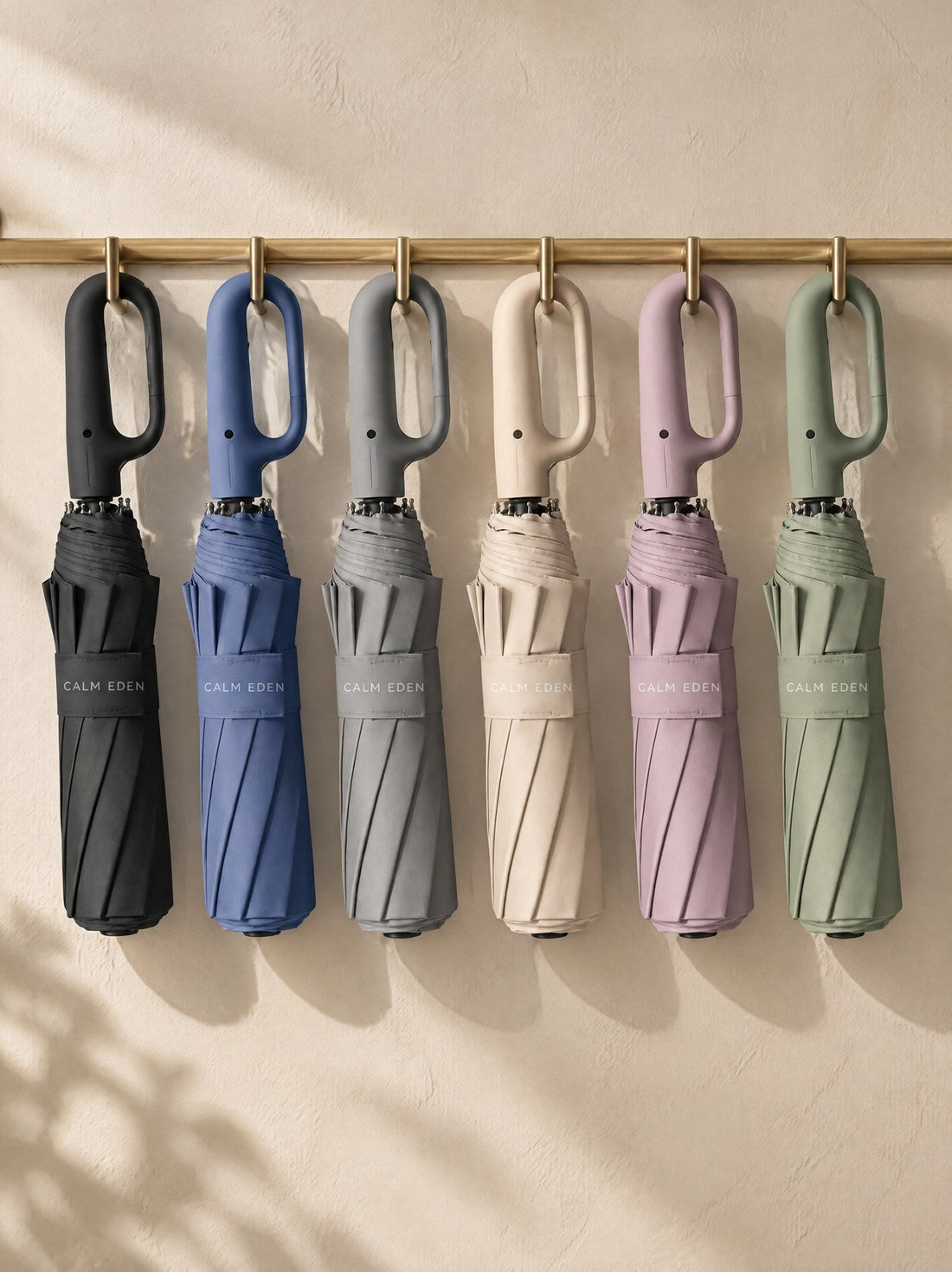 Haven umbrellas in six colours hanging on a rail by their carabiner handles