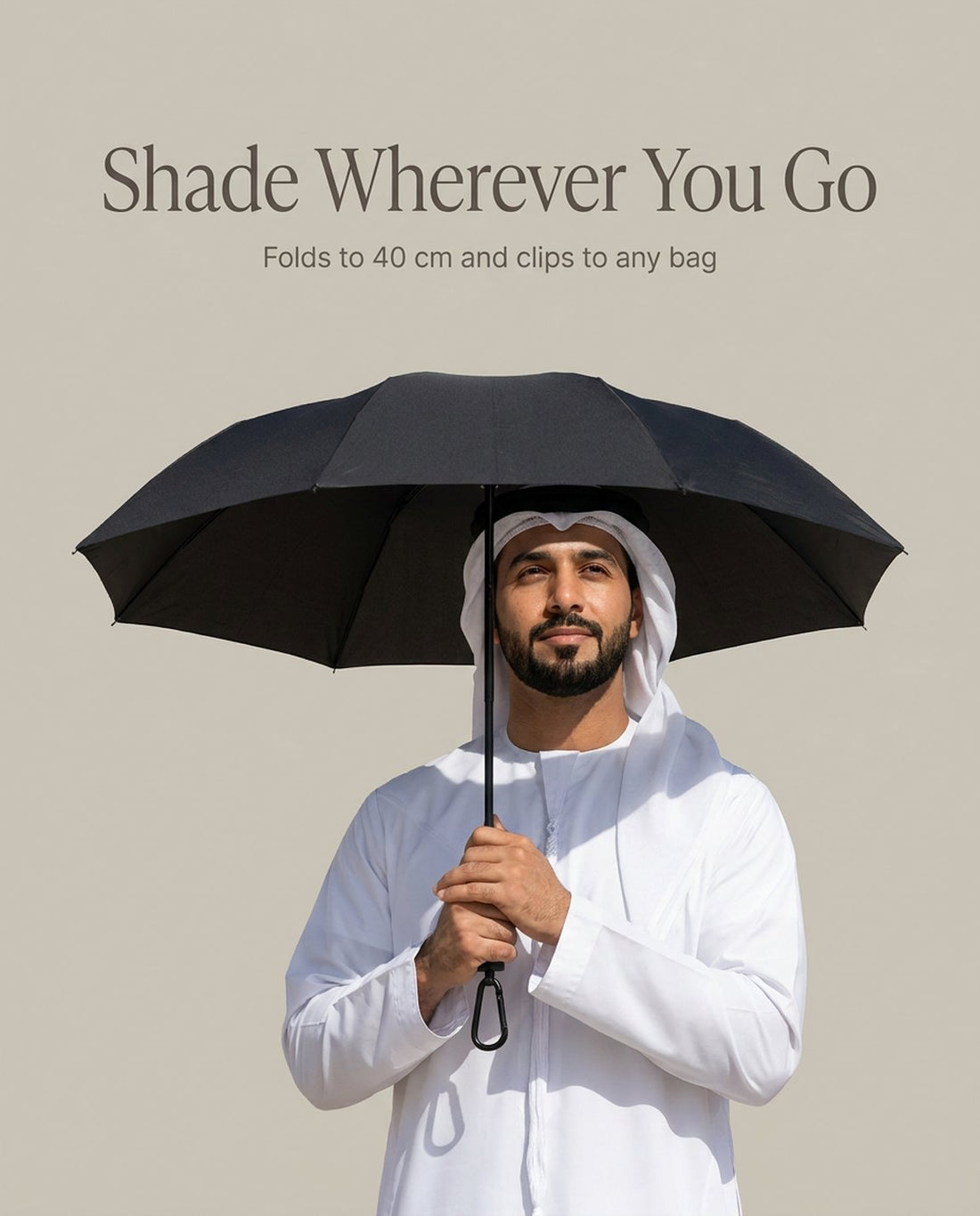 Man standing in the shade of an open black Haven umbrella held above his head