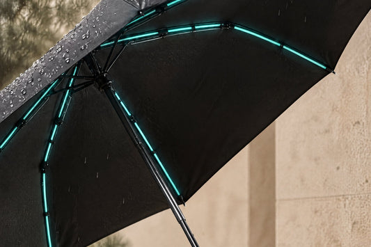 Open Haven Umbrella in rain with a black underside and reflective strips along the ribs