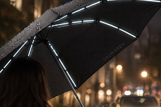 Open black Haven Umbrella at night, reflective strips under the canopy catching car headlights