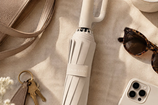 Beige Haven Umbrella laid flat beside a tote bag, keys and sunglasses