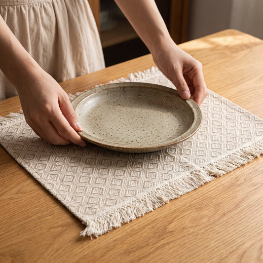 Setting a stoneware plate on the Hem™ Fringed Linen Placemat