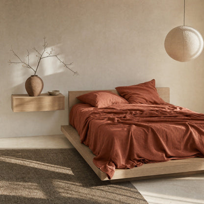 Clay linen flat sheet on oak platform bed in Japandi bedroom