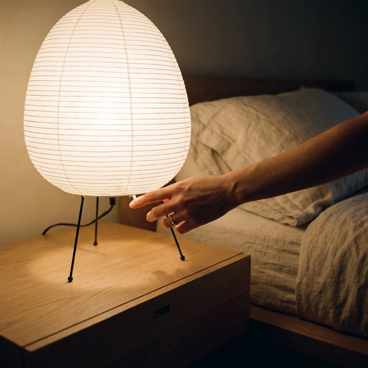Hand reaching to switch on the Washi™ Paper Lantern Lamp at night