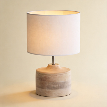 Grain™ Wood Table Lamp — whitewashed solid-wood base and linen drum shade glowing on warm cream background
