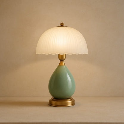 Petal ceramic table lamp with pleated glass shade on warm cream plaster