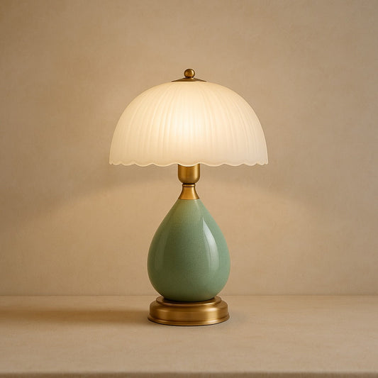 Petal ceramic table lamp with pleated glass shade on warm cream plaster