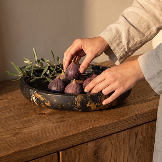 Arranging figs in the Nero Gold Quarry™ Marble Centerpiece Bowl