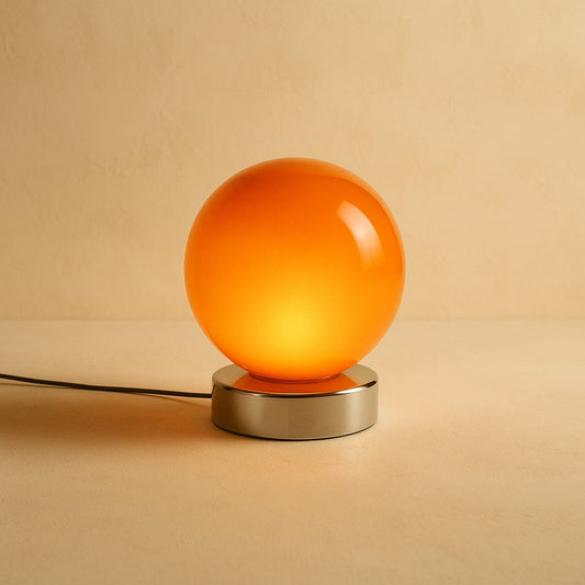 Ember glass globe lamp glowing on warm cream plaster