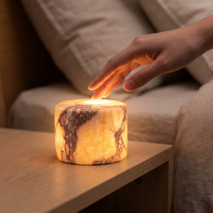 Hand tapping the top of the Aura™ Marble Tap Light to dim it at night