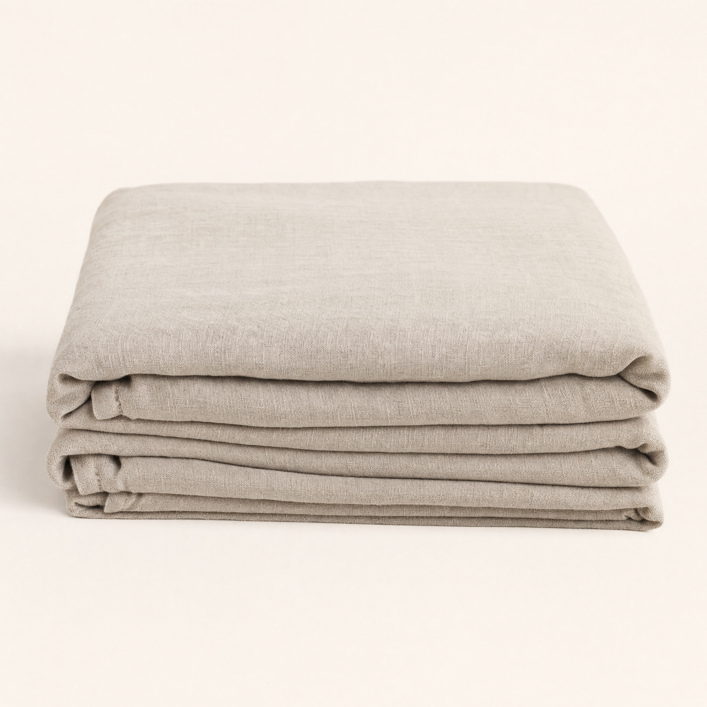 Flax oat French linen flat sheet folded on warm cream backdrop