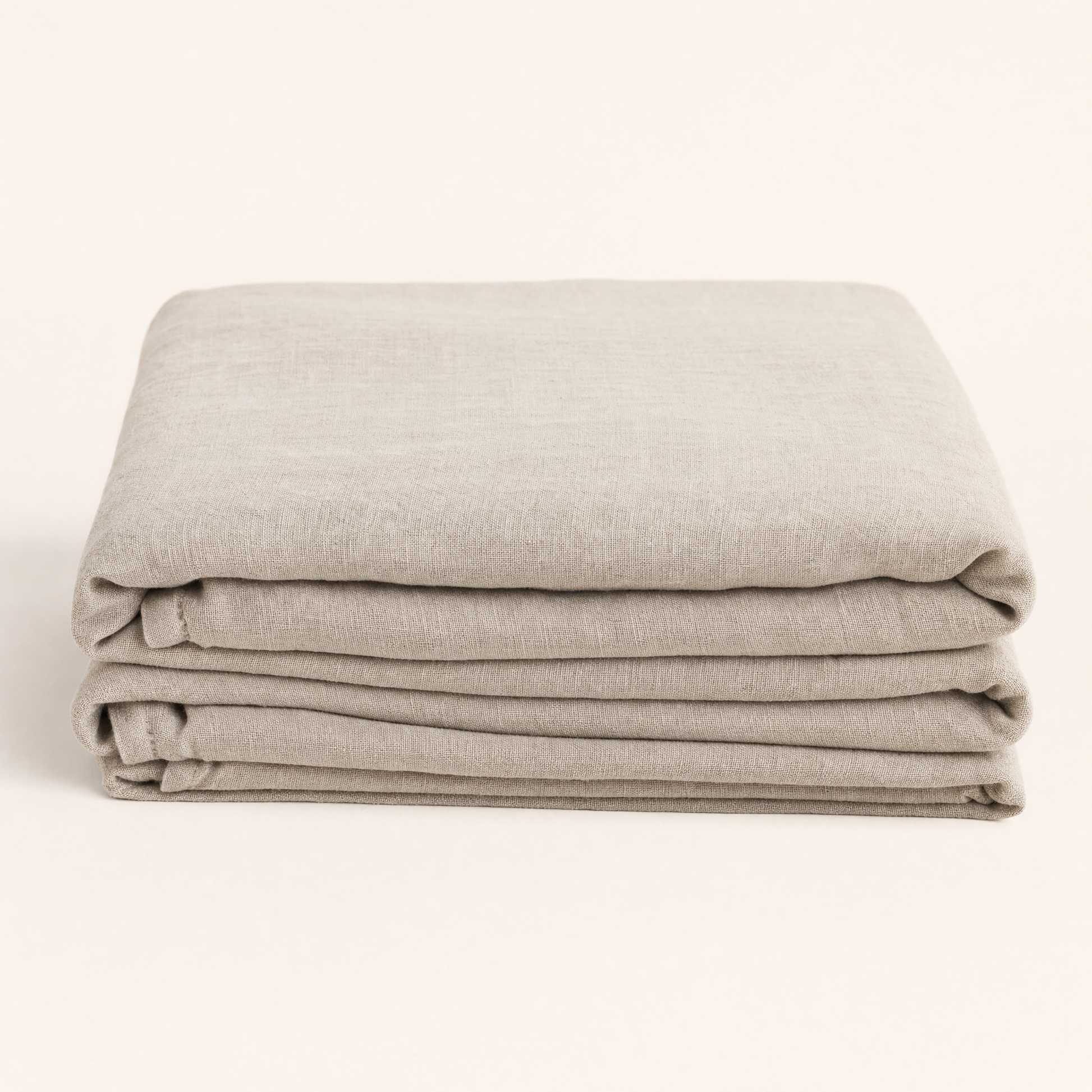 Flax oat French linen flat sheet folded on warm cream backdrop