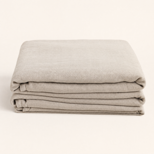 Flax oat French linen flat sheet folded on warm cream backdrop