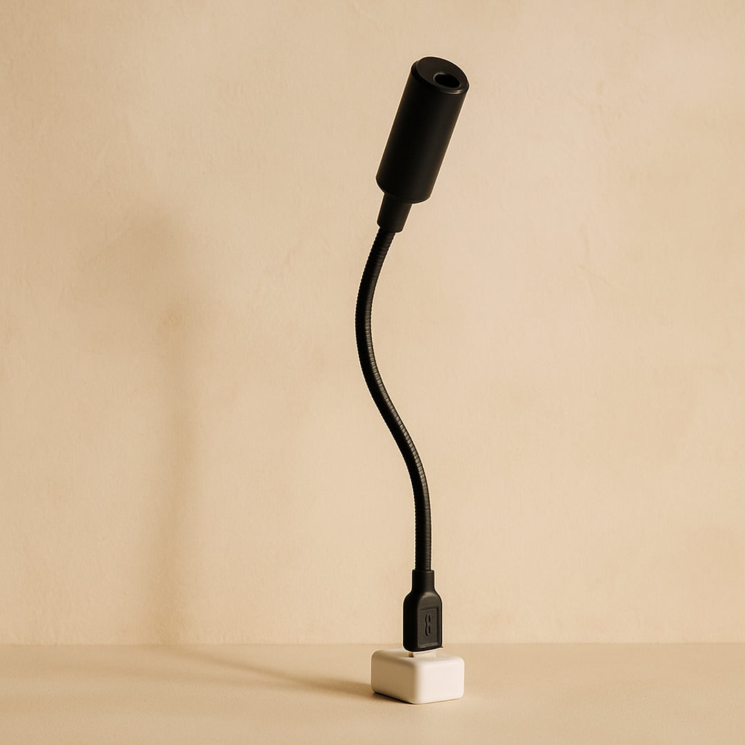 Orbit moon projector — black USB gooseneck on warm cream plaster