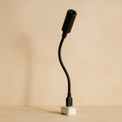 Orbit moon projector — black USB gooseneck on warm cream plaster