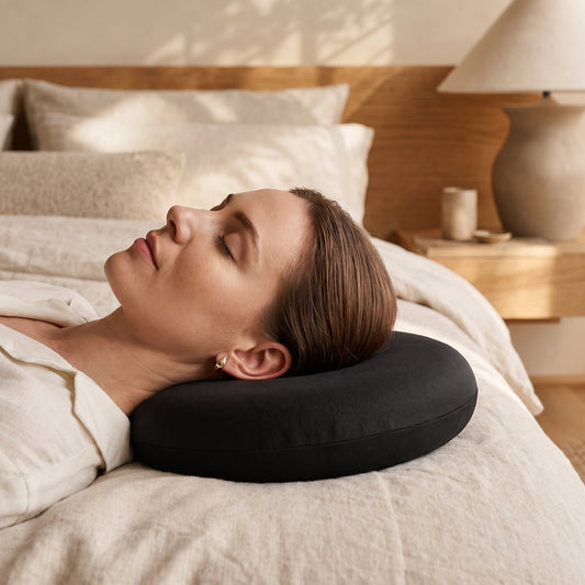 Side sleeper resting with her ear over the centre hole of the Ring™ Ear Relief Pillow