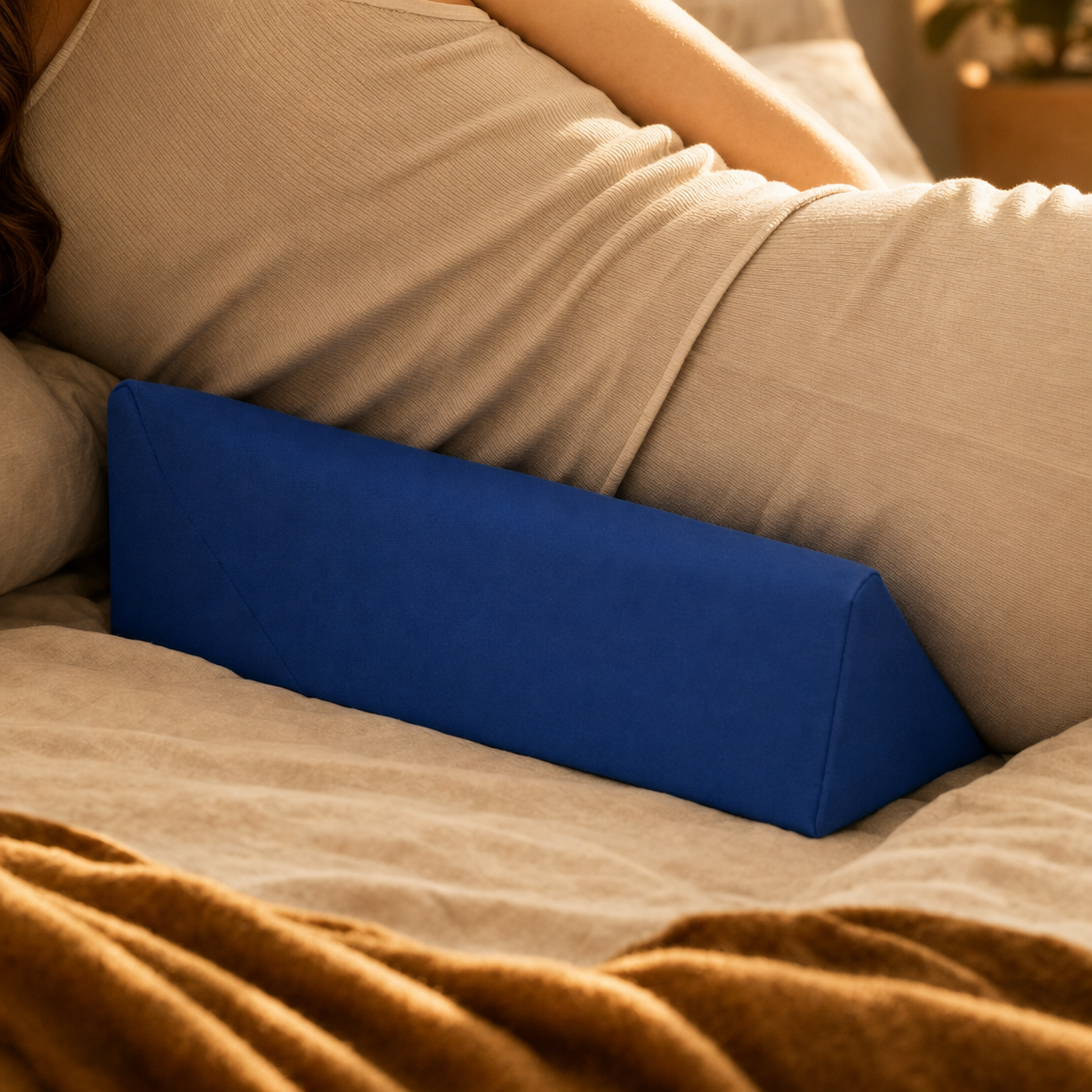 The CalmEden Anchor wedge's vertical face pressed against a side sleeper's lower back