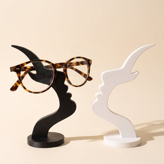 Visage™ Glasses Stand — black and white face-profile stands on warm cream background