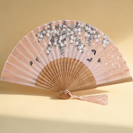 Sakura™ Silk Hand Fan — blush silk fan with sakura print and carved bamboo ribs on warm cream background