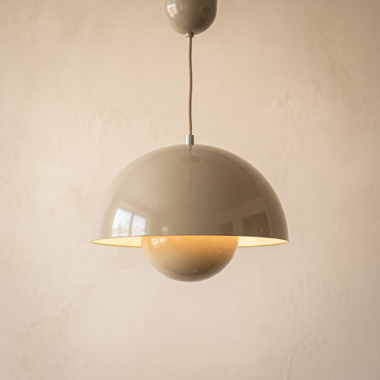Bud pendant light in putty grey hanging against a warm cream plaster wall