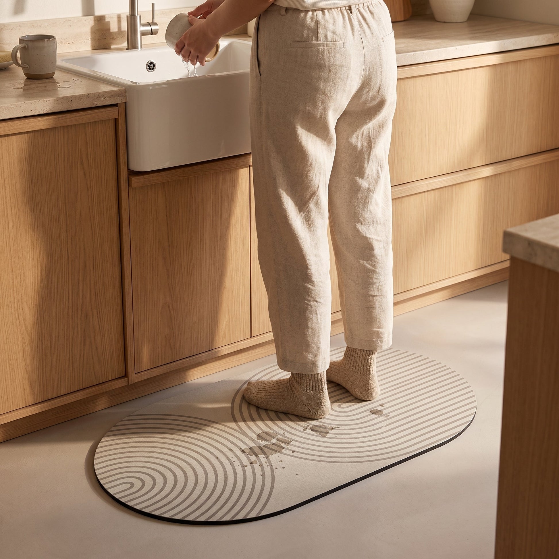 Washing up while standing on the Stone™ Quick-Dry Kitchen Mat as drips vanish