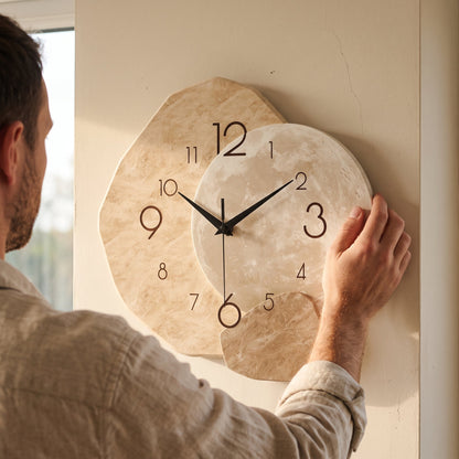 A man levelling the Cairn Clock on a plaster wall, showing its size against his hand