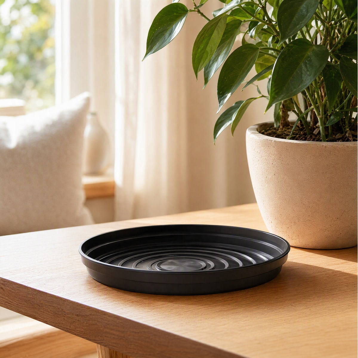 Roundrest™ Round Black Plastic Flower Pot Tray in a calm home setting