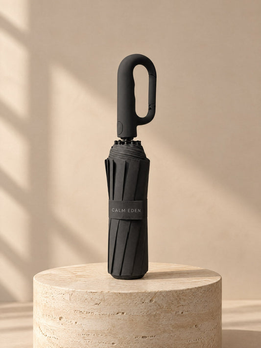 Haven umbrella in black, folded, on a stone plinth
