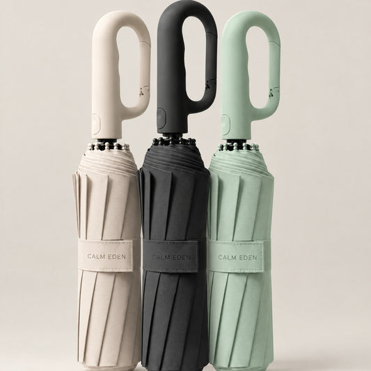 Three folded Haven compact umbrellas in beige, black and sage green with carabiner handles
