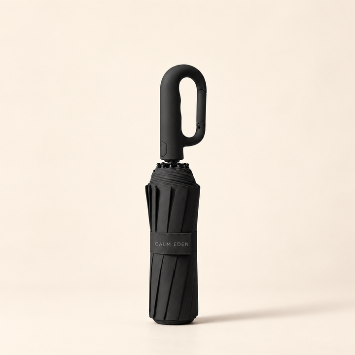 Folded black Haven umbrella on a warm ivory background