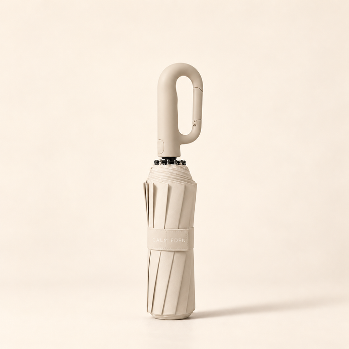 Folded beige Haven umbrella on a warm ivory background