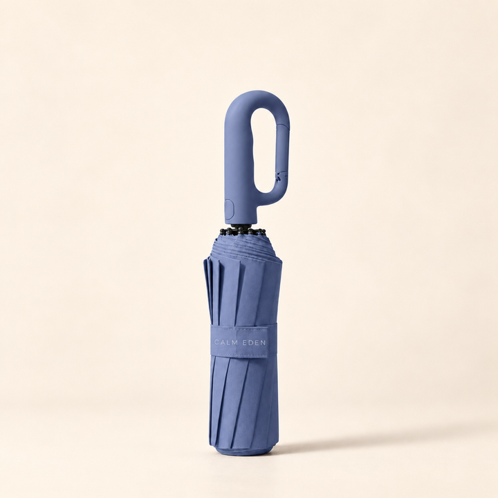 Folded blue Haven umbrella on a warm ivory background