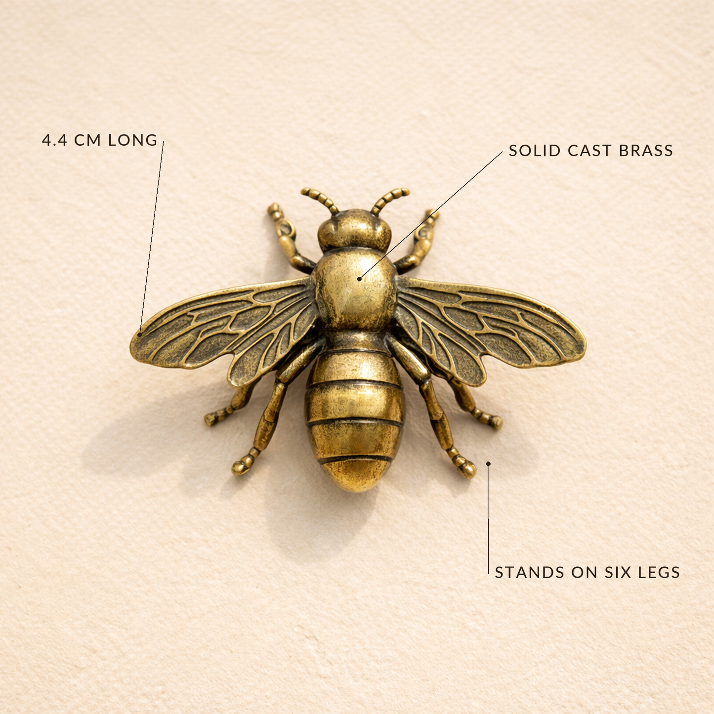 Overhead view of the brass bee with labels reading 4.4 cm long, solid cast brass, stands on six legs