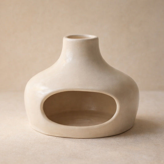 Cinder ceramic palo santo burner with chimney spout on warm cream plaster