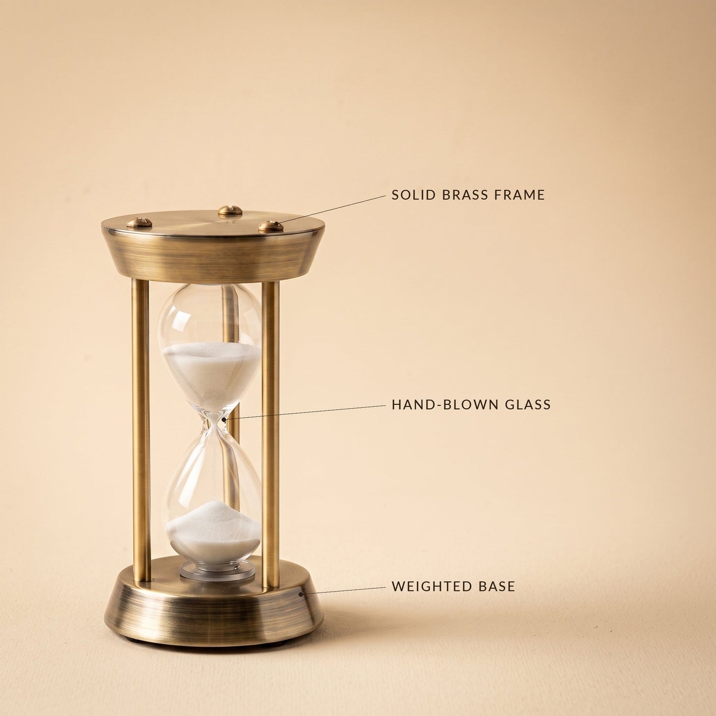 Ebb™ Sand Timer detail — solid brass frame, hand-blown glass, weighted base