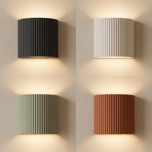 Flute fluted wall sconces in charcoal, white, sage and terracotta lit on warm cream plaster