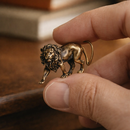 Leo™ Brass Lion held between thumb and finger, showing its true 38.5 mm scale
