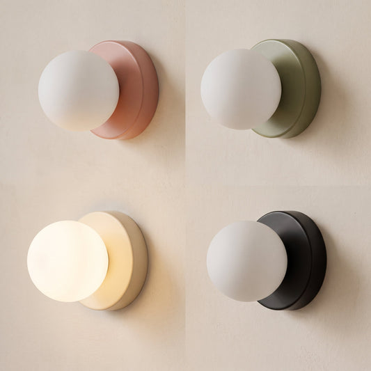 Orb opal glass wall sconces with cream, sage, blush and charcoal discs on warm cream plaster