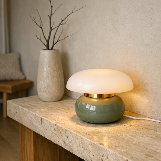 Pillar Dome Lamp in Sage Green lit on a travertine console in a minimalist room
