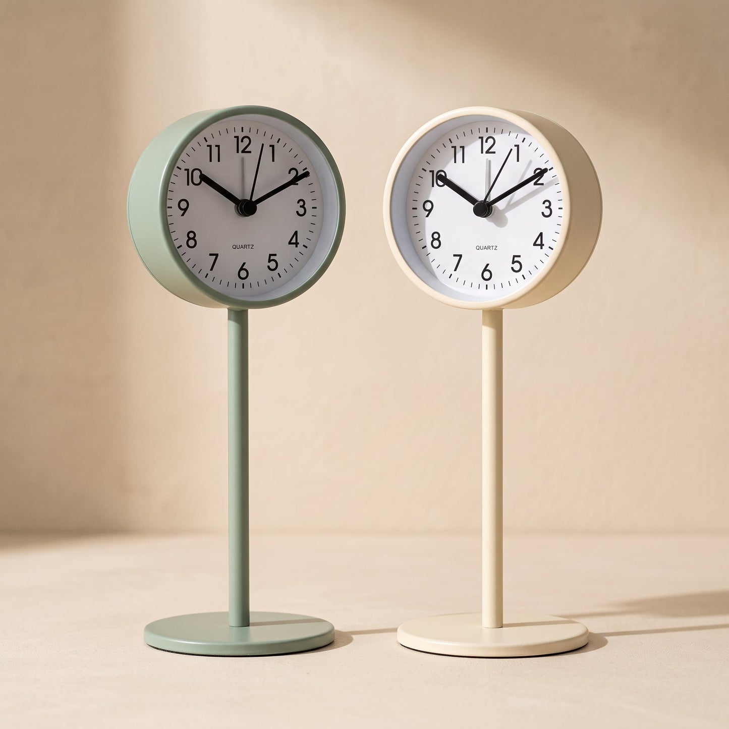Perch™ pedestal clocks in sage and cream on a warm cream surface
