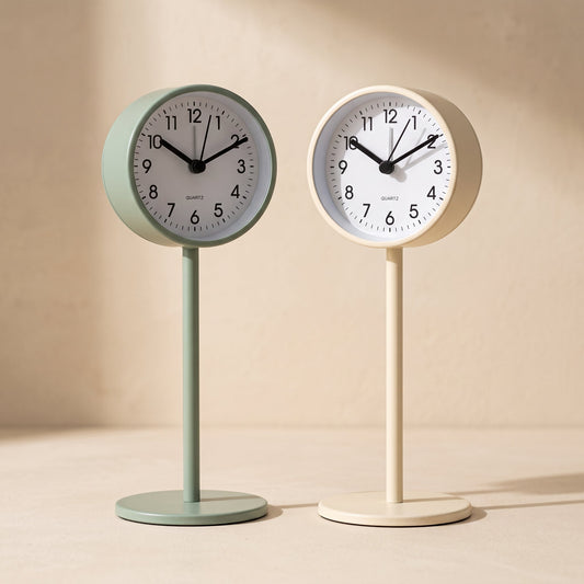 Perch™ pedestal clocks in sage and cream on a warm cream surface